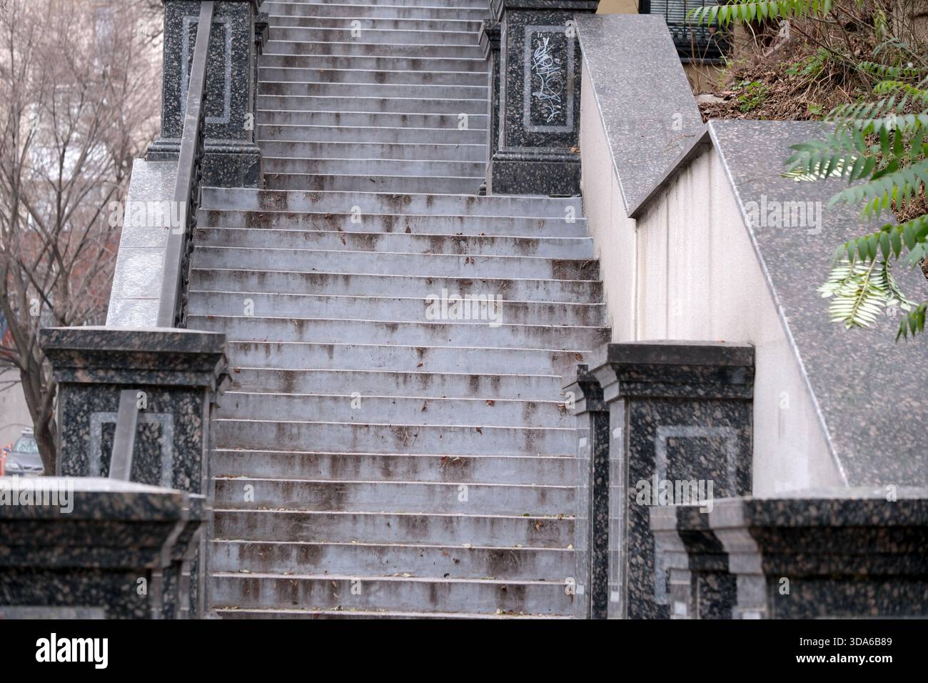 Geheimnisvolle graue Stufen erheben sich sanft und laden zur ruhigen Reflexion in der Stadt ein. Stockfoto