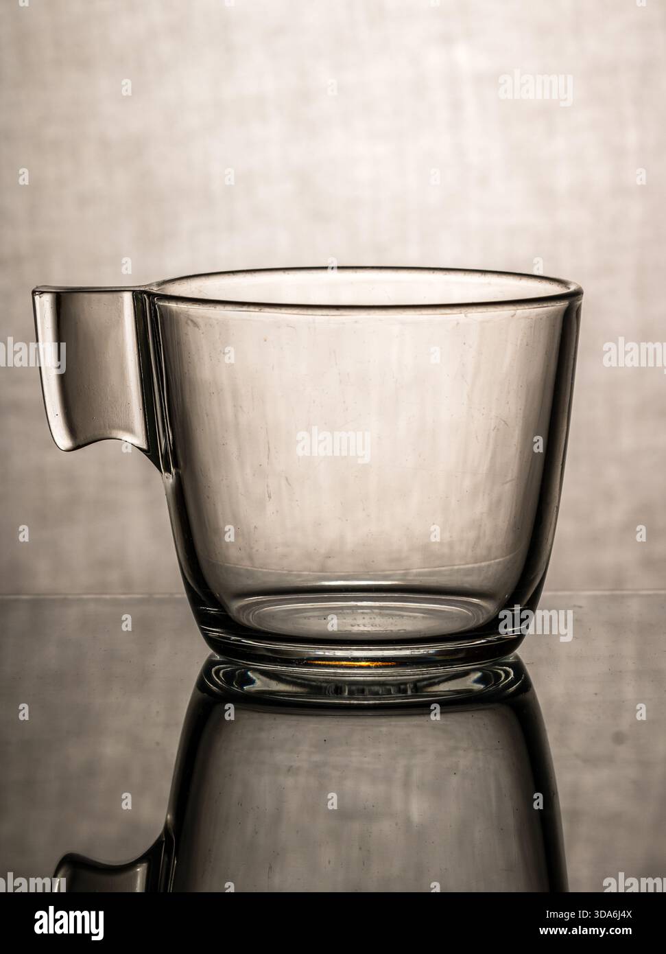 Leere Espresso-Kaffeetasse mit Reflexion auf strukturiertem grauen Hintergrund Stockfoto