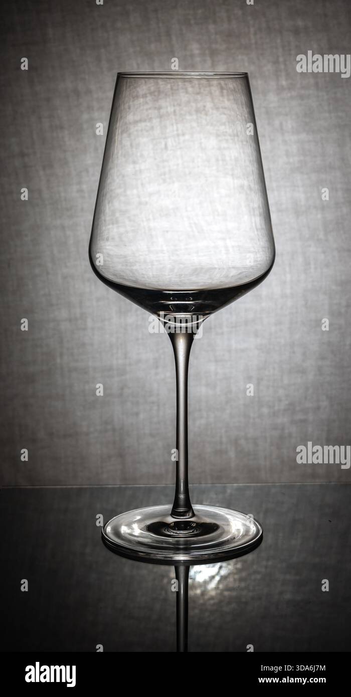 Leeres Weinglas mit eckiger Schüssel auf reflektierender Oberfläche Stockfoto