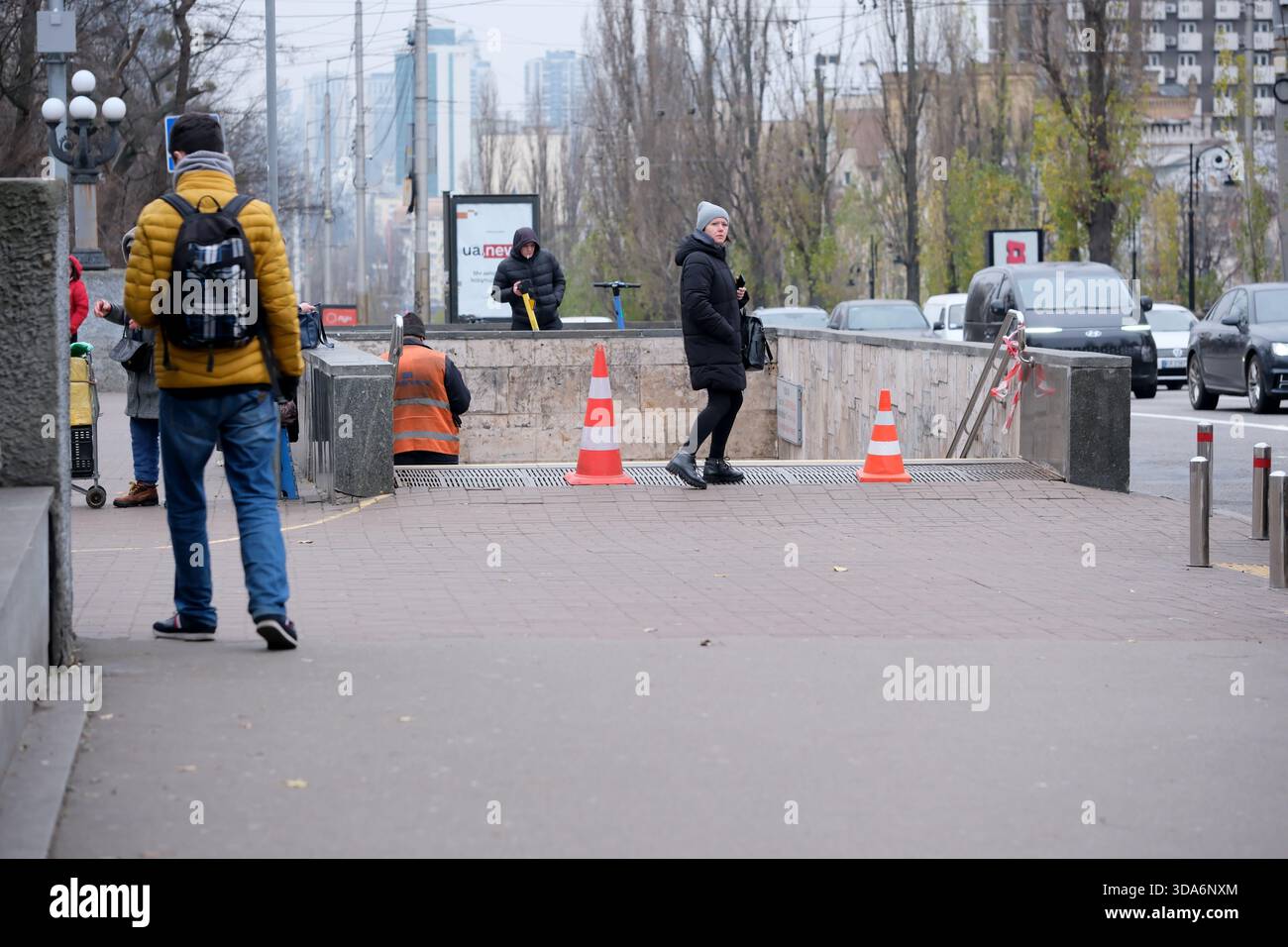Die Menschen bewegen sich an einem kühlen Tag in warmer Kleidung durch eine geschäftige Stadtstraße. Kiew, Ukraine. Dezember 2025. Stockfoto