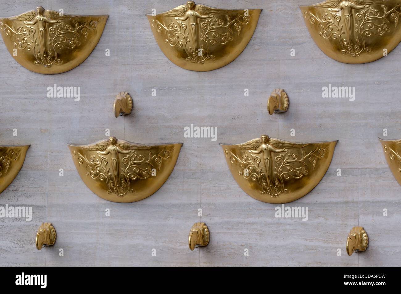 Glitzernde goldene Motive zieren eine strukturierte Wand, die künstlerische Handwerkskunst zum Ausdruck bringt. Kiew, Ukraine. Dezember 2025. Stockfoto