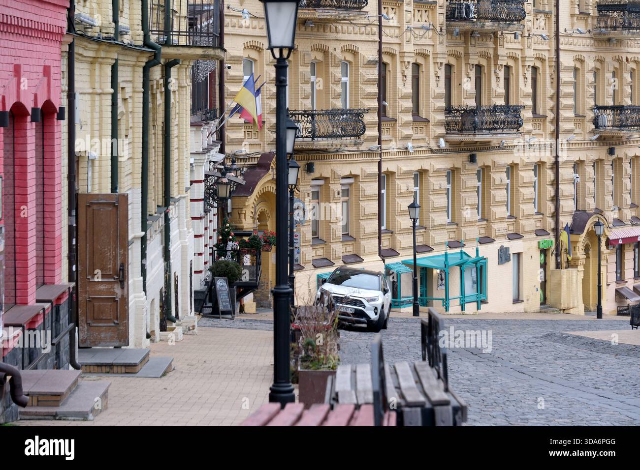 Eine malerische Straße mit bunten Gebäuden, einladenden Geschäften und einer ruhigen Atmosphäre. Kiew, Ukraine. Dezember 2025. Stockfoto