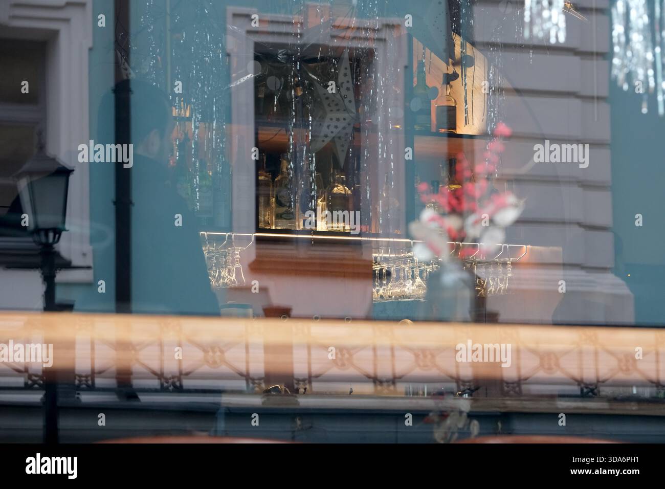 Sanftes Sonnenlicht erhellt ein malerisches Café mit charmantem Dekor und leuchtenden Blumen. Kiew, Ukraine. Dezember 2025. Stockfoto