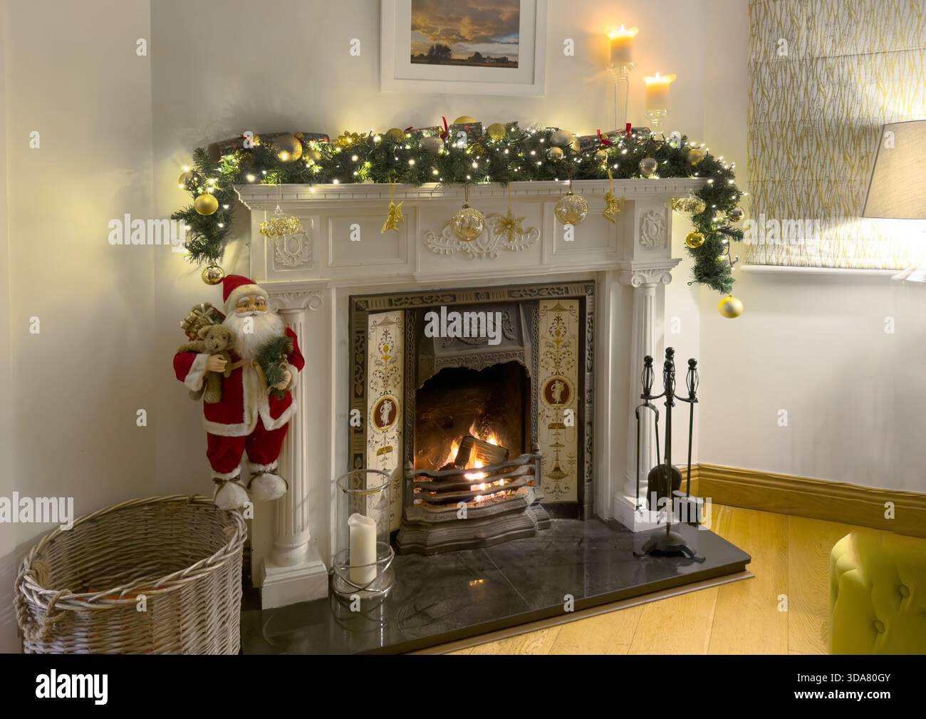 Ein traditioneller Kamin und Kaminsims, dekoriert für Weihnachten mit einer Girlande und Feenlichtern in einem Wohnzimmer Stockfoto