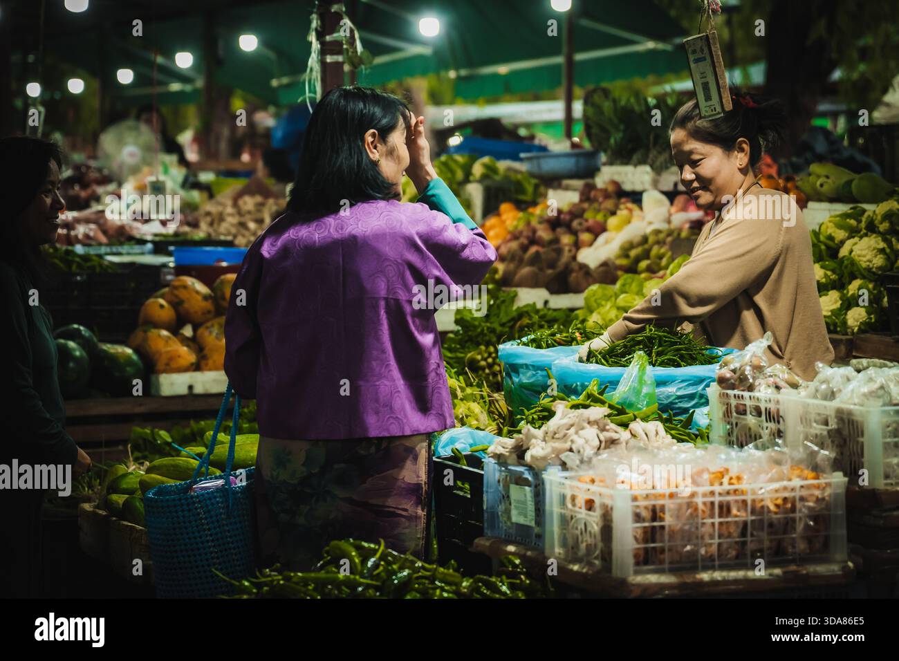 Paro, Bhutan - 17. September 2025: Blick auf eine geschäftige Marktszene, in der lebhafte Produkte im Kontrast zum warmen Leuchten der Deckenleuchten stehen Stockfoto