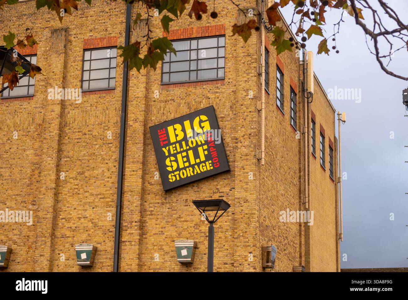 LONDON - 7. NOVEMBER 2025: Big Yellow Self Storage bold-Schild auf gelbem Backsteinlager - Townmead Road, Fulham Stockfoto