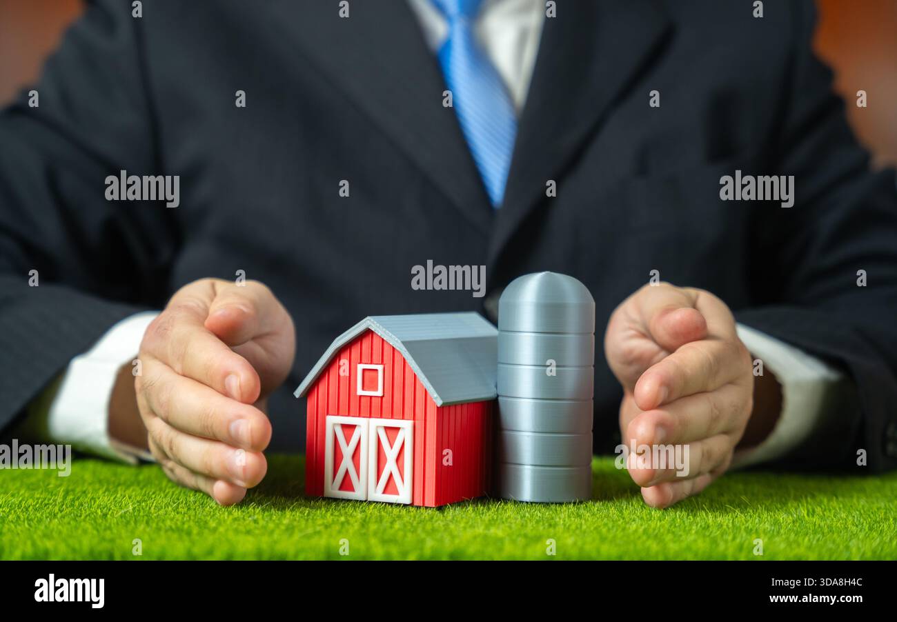 Ein Geschäftsmann umarmt eine Farm zur Verteidigung. Unterstützung der nationalen Agrarindustrie und Schutz der Interessen der Landwirte. Wirtschaftlicher Schutz, ländlicher Raum Stockfoto