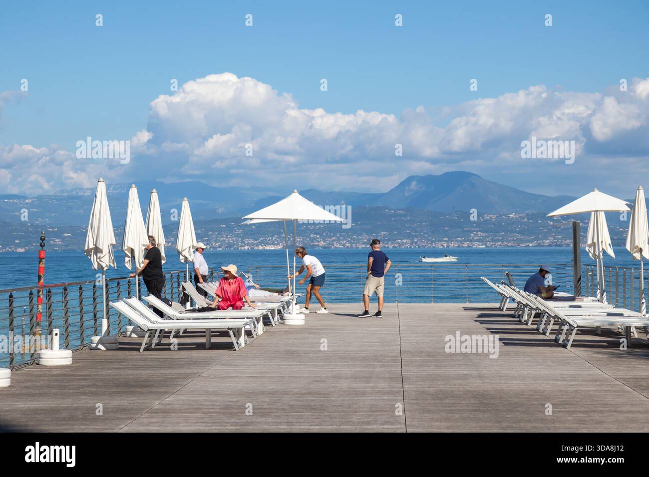 Italien, Sirmione - 27. September 2025: Privater Bootsanleger im Palace Hotel Villa Cortine in Sirmione, Italien, mit Blick auf den Gardasee und die umliegenden berge Stockfoto