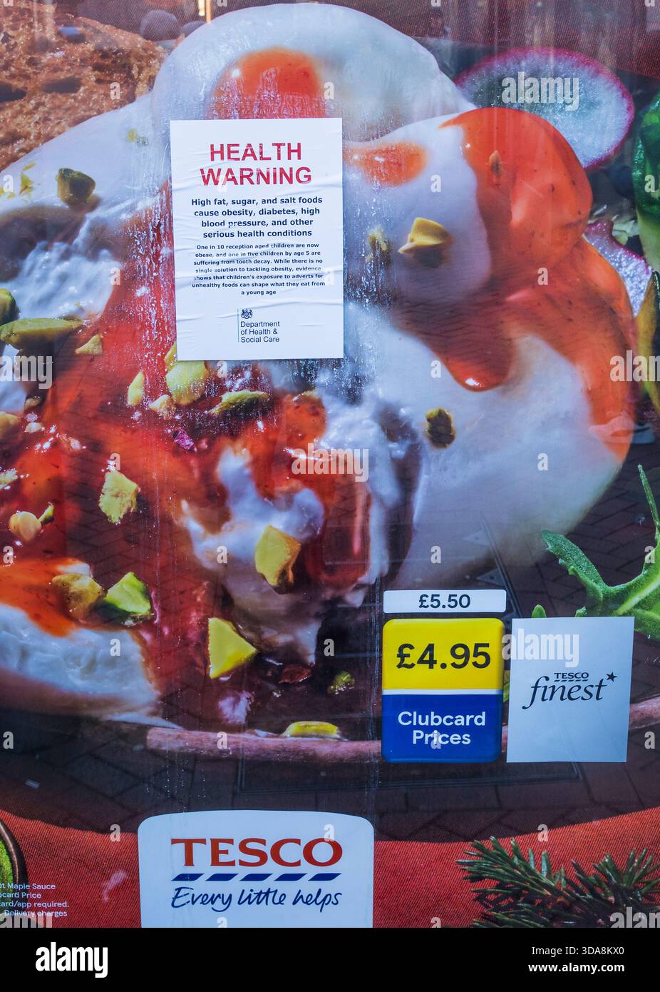 Gesundheitswarnung, ( nicht vom Gesundheitsministerium ), ungesundes Essen, platziert auf Tesco Food Reklame, Reading, Berkshire, England, Großbritannien, GB Stockfoto