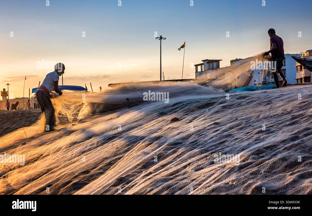 Fischer bereiten Fischernetze bei Sonnenuntergang vor, Puri Beach, Odisha, Indien Stockfoto