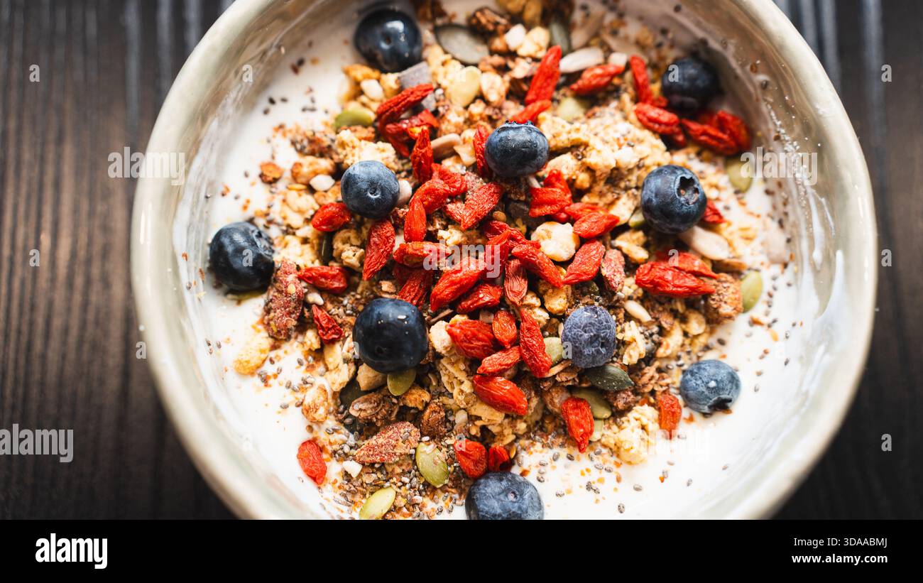 Proteinreicher Joghurt mit Molke, Heidelbeeren, Goji-Beeren und knusprigem Granola. Ideal nach dem Workout oder proteinreiches Frühstück für Muskelregeneration und Stockfoto