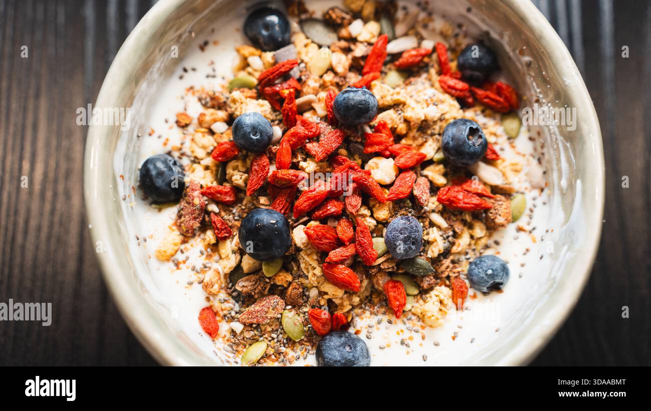 Proteinreicher Joghurt mit Molke, Heidelbeeren, Goji-Beeren und knusprigem Granola. Ideal nach dem Workout oder proteinreiches Frühstück für Muskelregeneration und Stockfoto