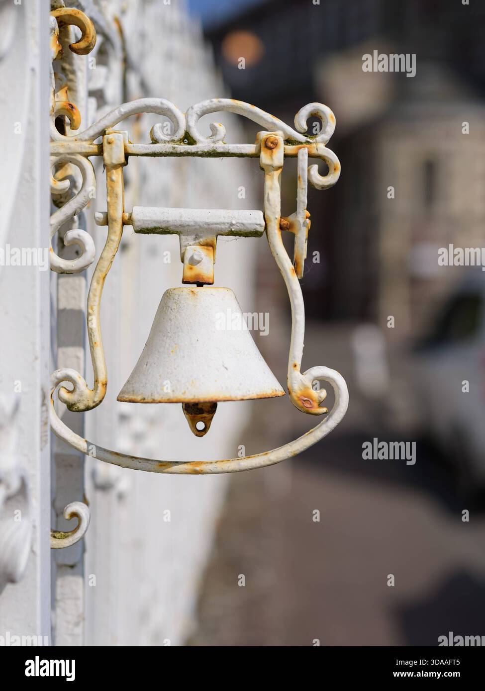 Eine kleine weiße Metallglocke ist während der Sommersaison an der Außenwand eines Hauses in Yport, Frankreich, angebracht. Yport Frankreich Stockfoto
