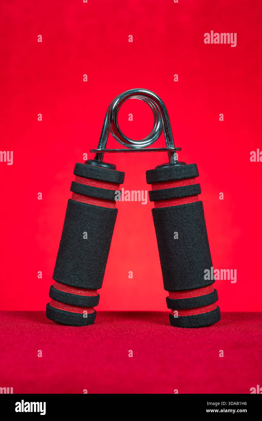 Handtrainer auf rotem Hintergrund Stockfoto