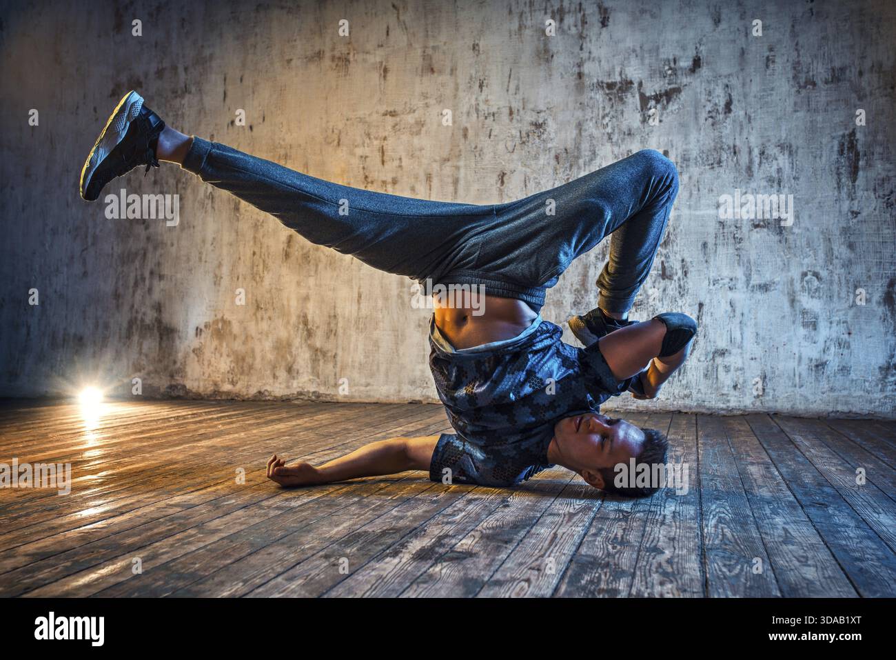 Junger Mann Breakdance auf Wand Hintergrund Stockfoto