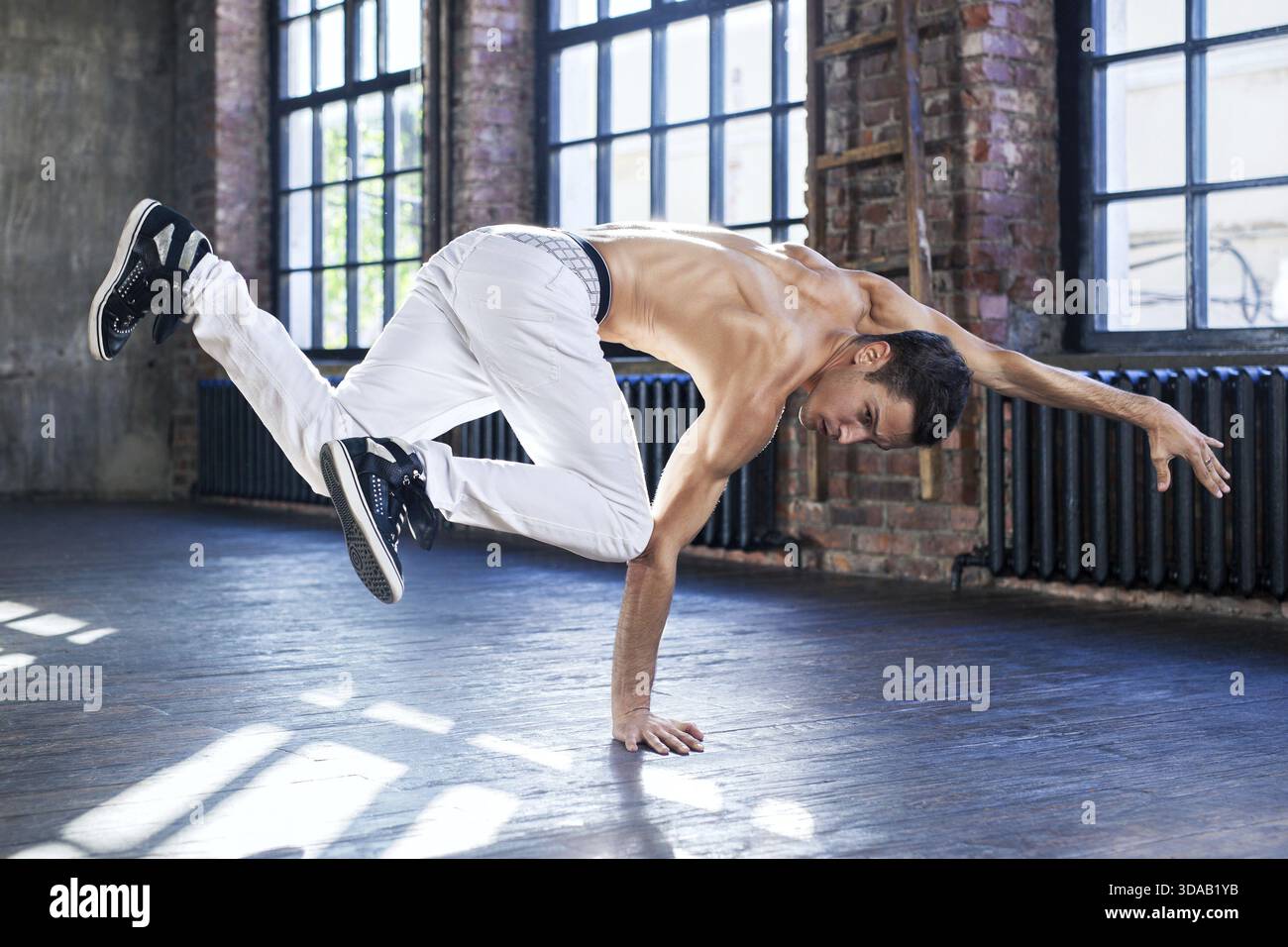 Junger Mann Breakdance in alten sonnigen städtische Interieur Stockfoto