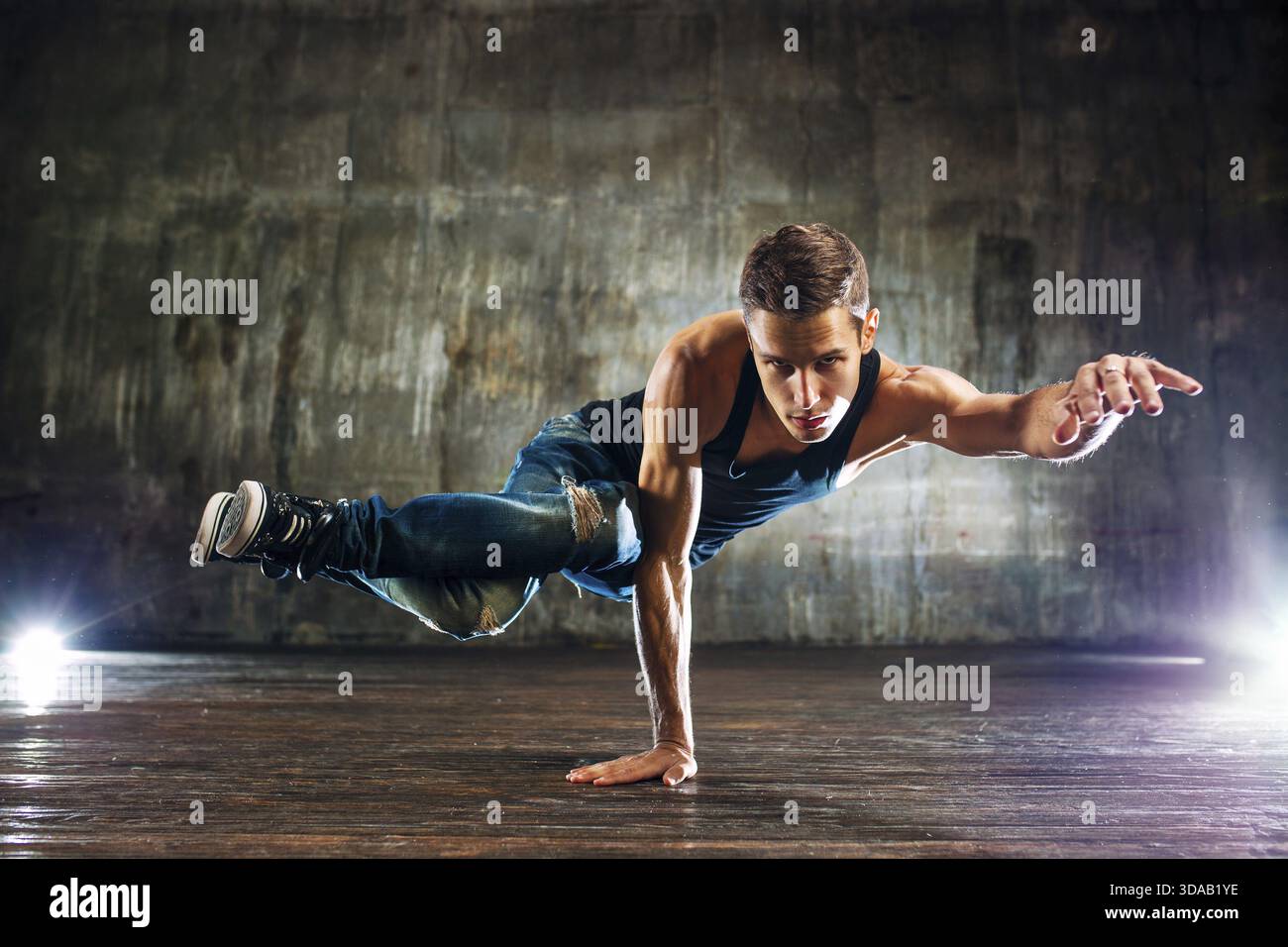 Junger Mann, Breakdance und stehen auf der einen Seite auf alten Mauer Hintergrund Stockfoto