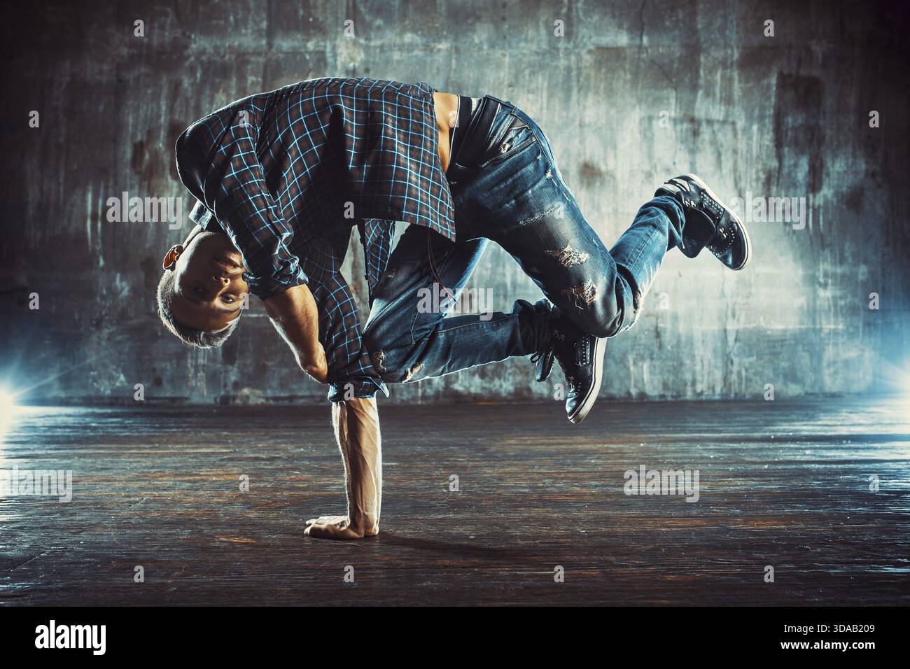 Junger Mann in t-Shirt und Jeans Breakdance auf alten Mauer Hintergrund Stockfoto