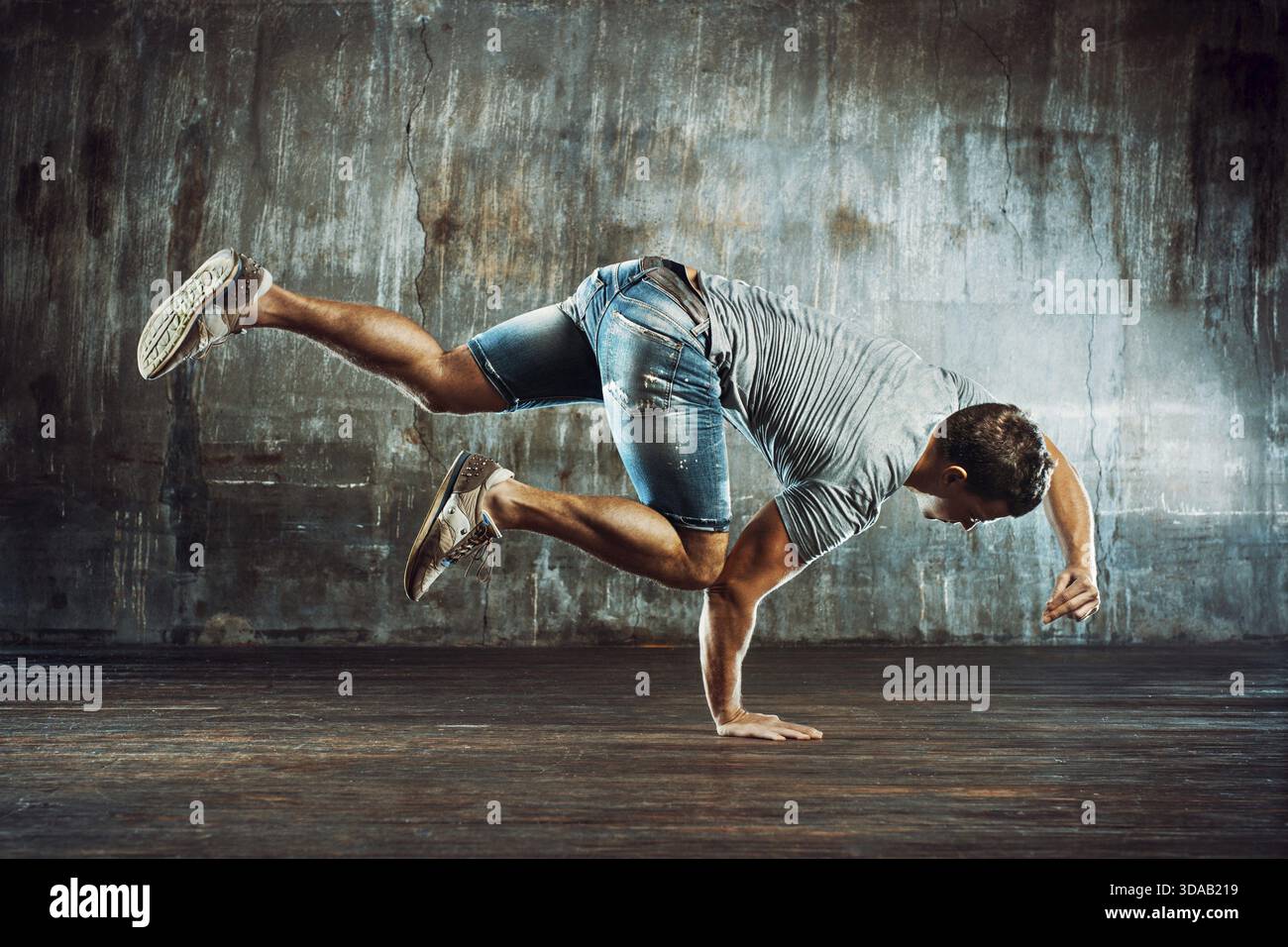 Starker junger Mann Breakdance auf alten Mauer Hintergrund Stockfoto