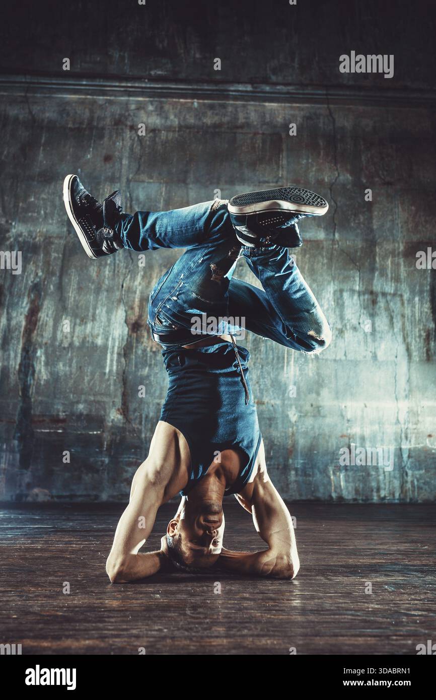 Junger Mann, der auf alter Wand tanzt. Farben im Vintage-Filmstil Stockfoto