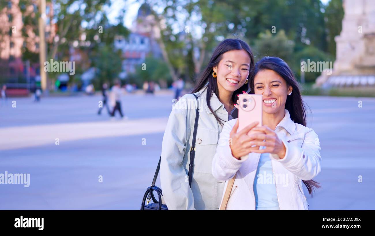 Verschiedene junge Frauen machen gemeinsam Selfie im Freien Stockfoto