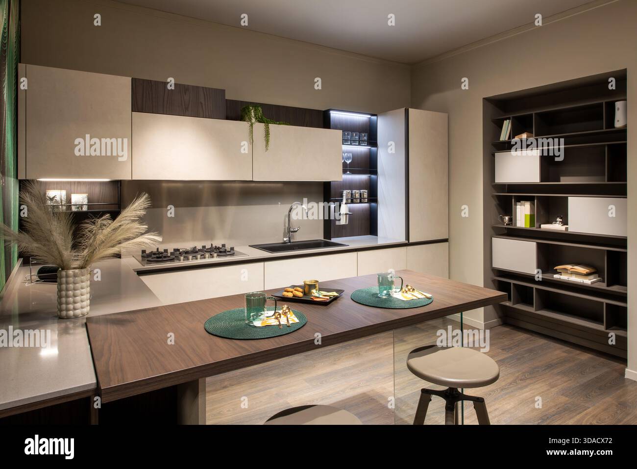 Moderne Küche mit minimalistischem Design, eleganten Schränken und einer Holzinsel zum Frühstück Stockfoto