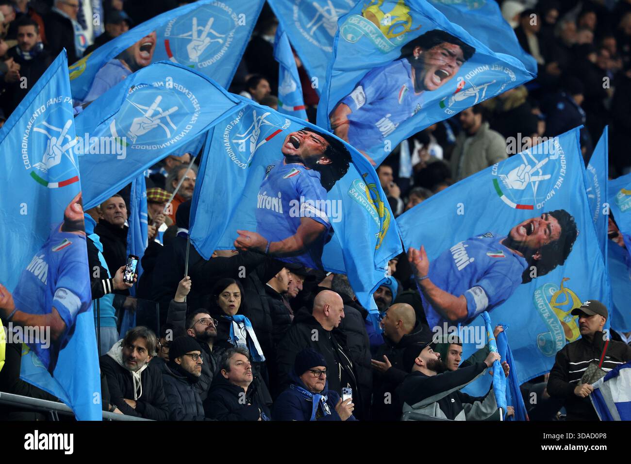 Die Anhänger des SSC Napoli schwingen die Flagge mit Porträts von Diego Armardo Maradona während des Fußballspiels der Serie A 2025/2026 zwischen dem SSC Napoli und Juventus FC im Diego Armando Maradona Stadion in Neapel (Italien) am 7. Dezember 2025. Stockfoto