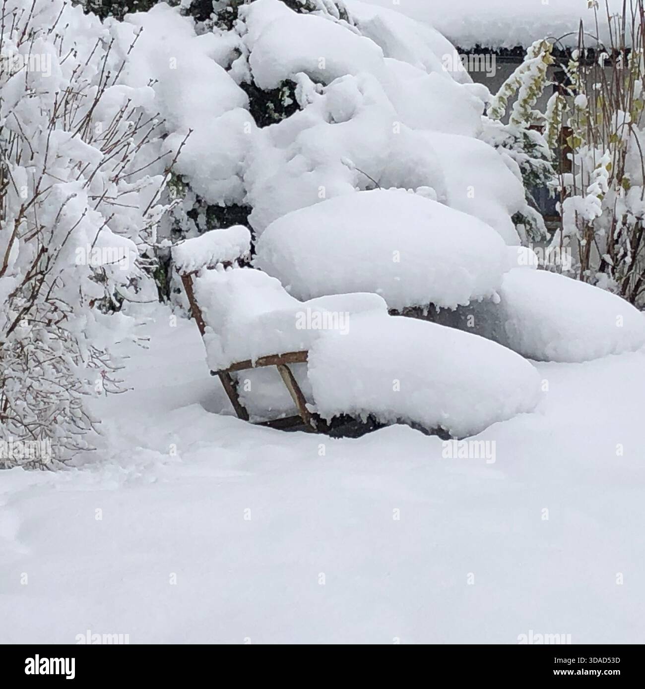 Eine dicke Schneedecke hat die Gartenstühle vollständig vergraben und verwandelt die Terrassenmöbel in weiche weiße Skulpturen. Foto: Willy Matheisl Stockfoto