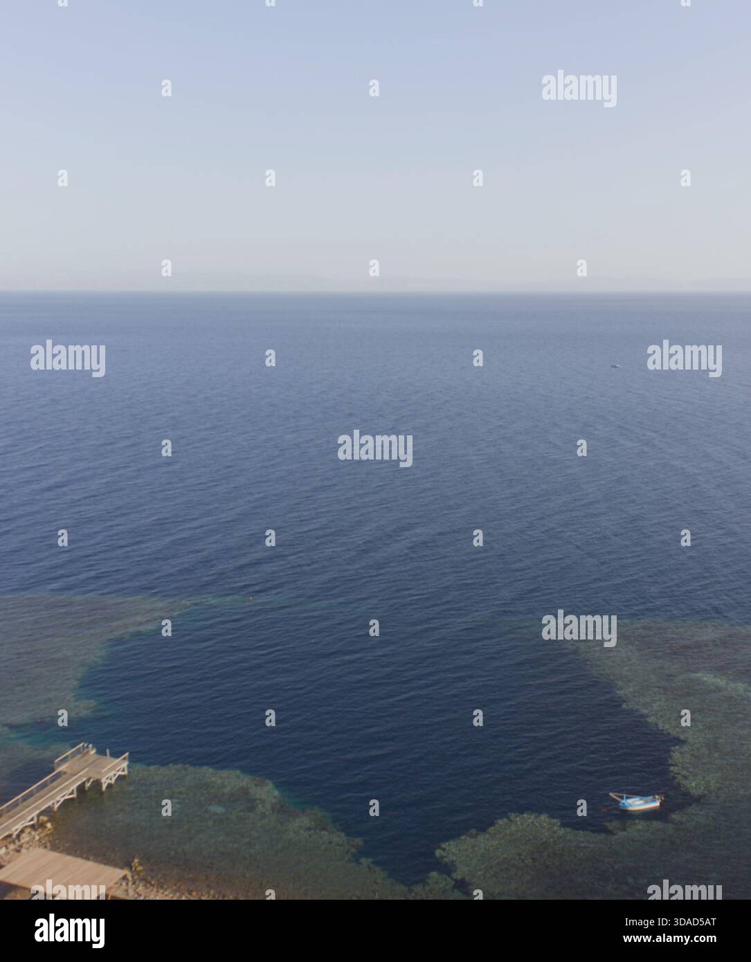 Blick aus der Vogelperspektive auf den Tauchplatz Blue Hole in der Nähe von Dahab, Ägypten, mit tiefblauem Wasser und umliegenden Korallenriffen im Roten Meer. Stockfoto