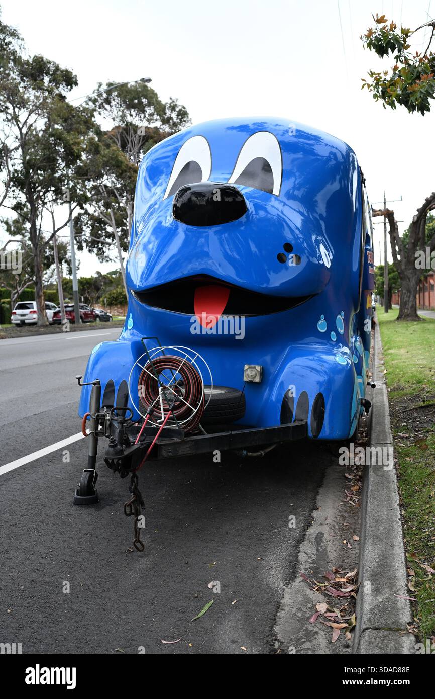 Vorderansicht des niedlichen Hundewaschanhängers Blue Wheelers, der an einem bewölkten Tag am Straßenrand geparkt ist Stockfoto