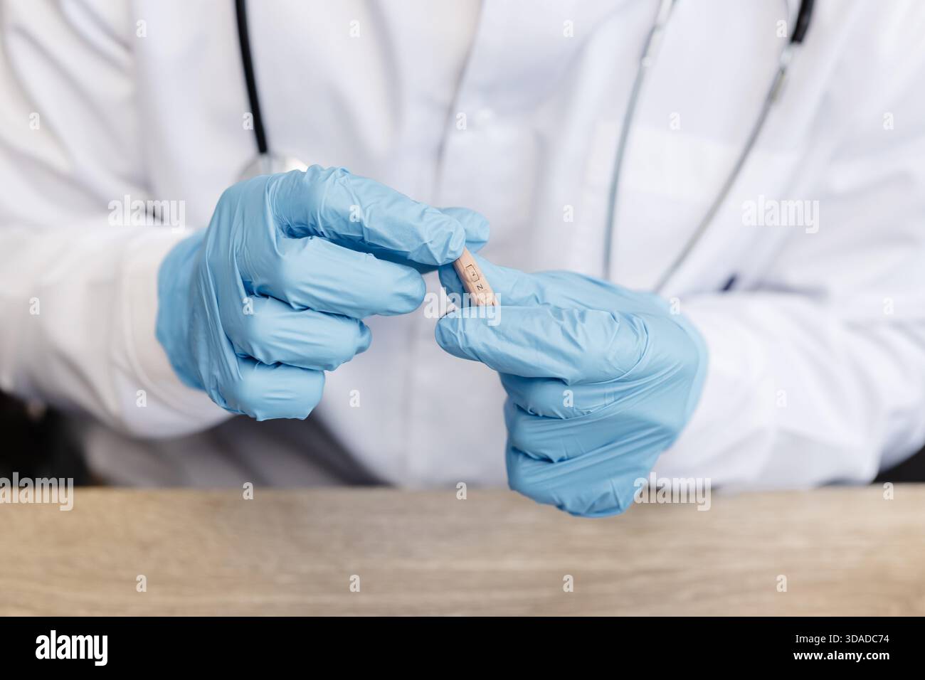 Ein HNO-Arzt hält ein Hörgerät in den Händen. Der Arzt konsultiert den Patienten. Stockfoto