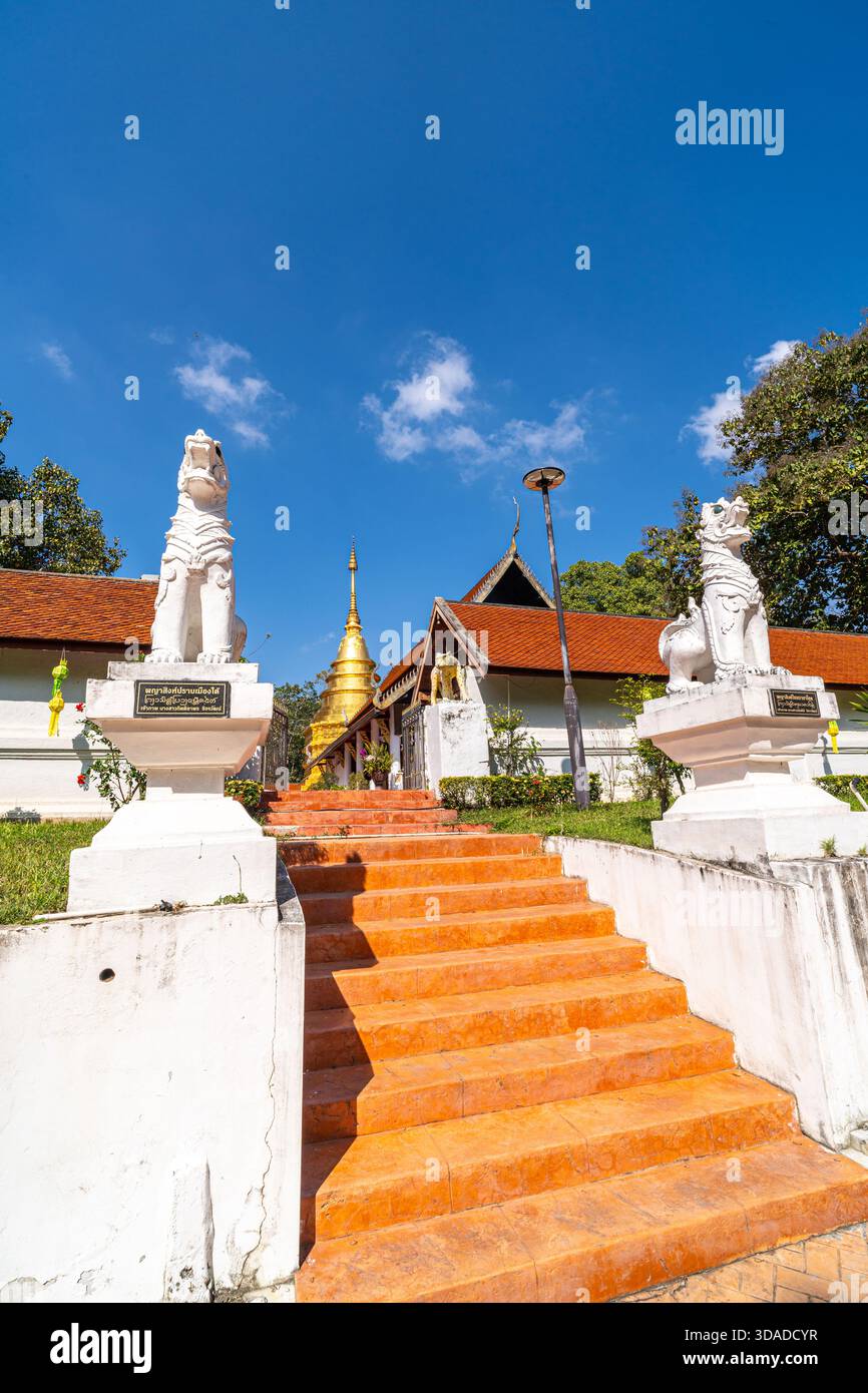 MUANG, PHAYAO, THAILAND - 10. DEZEMBER 2025: Wat Phra That Chom Thong, breite orangene Treppen führen zu einem Tempeleingang, der von zwei großen weißen Löwen bewacht wird Stockfoto