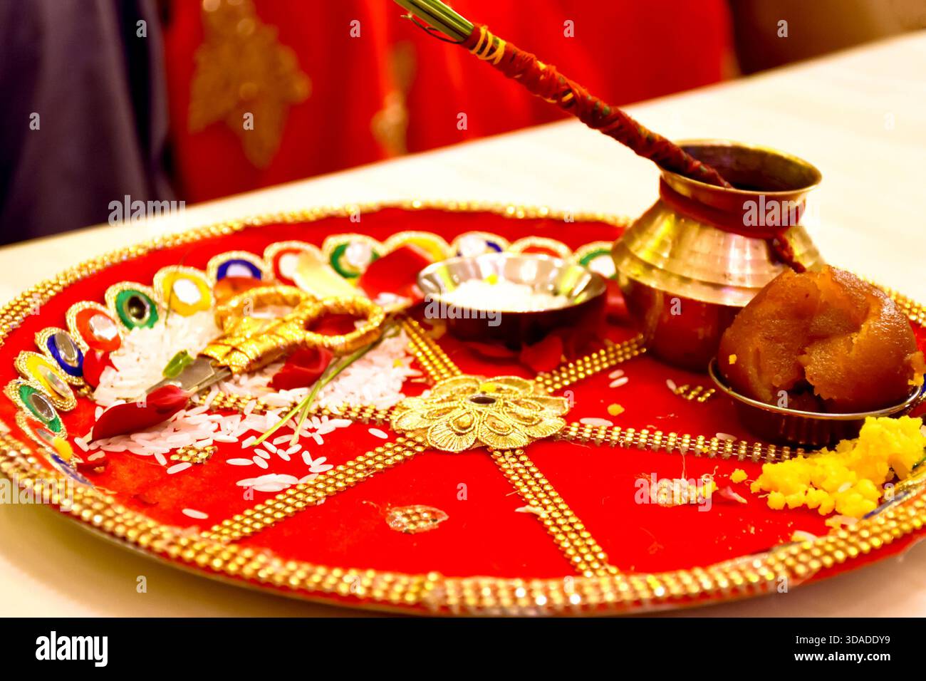 Ein wunderschön dekorierter roter Hochzeits-Thali, der während des Bändchenschneiderrituals bei indischen Hochzeiten verwendet wurde Stockfoto
