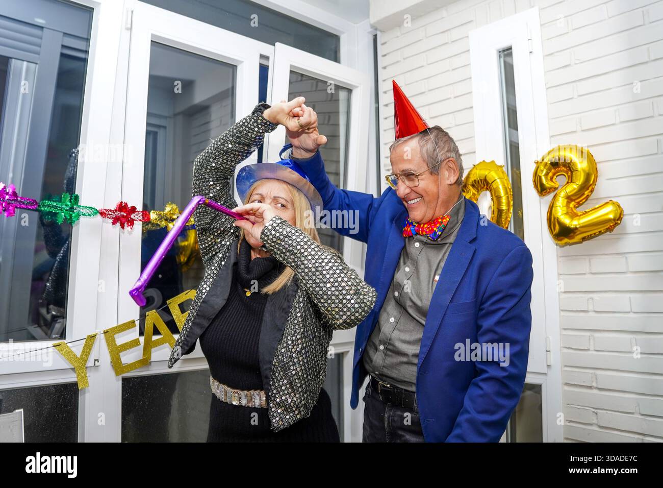 Festliches Seniorenpaar, das an Silvester Spaß hat Stockfoto