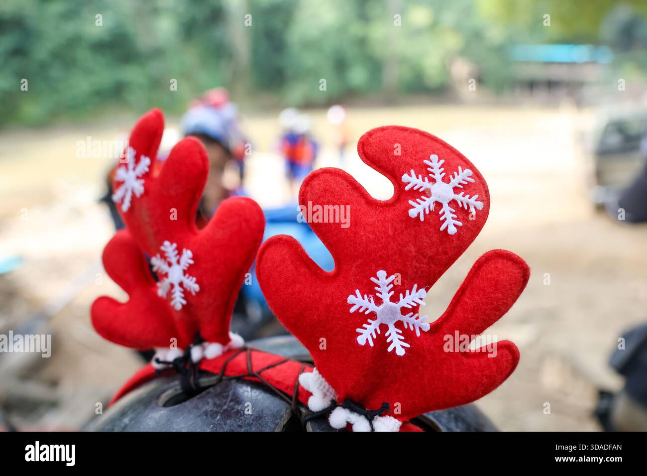Festliches rotes Rentiergeweih-Stirnband mit weißer Schneeflockendekoration. Lustiges Accessoire, das fröhliche Weihnachtsstimmung auf jede Feier bringt, verspieltes Symbol Stockfoto