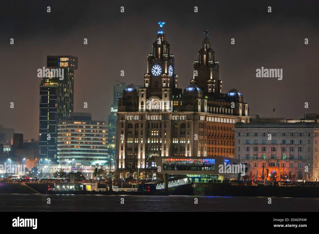 Royal Liver Gebäude mit Flutlicht, Liverpool Pierhead am Wasser bei Nacht. L zum Beetham Tower, dem Mercurte Hotel, Lebergebäude, Cunard Gebäude. Stockfoto