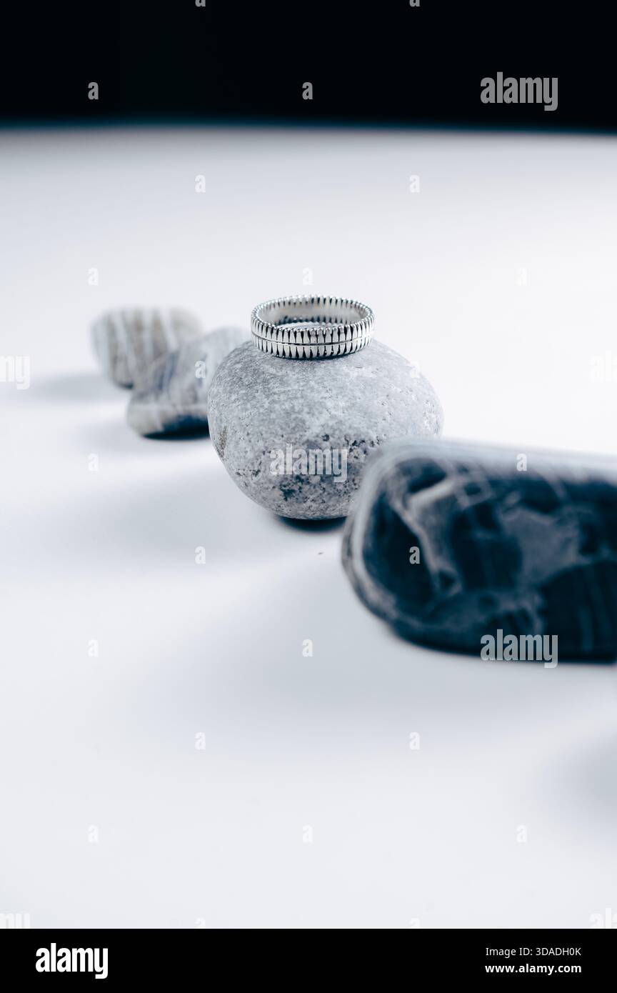 Nahaufnahme eines silbernen Rings auf einer Reihe grauer Steine Stockfoto