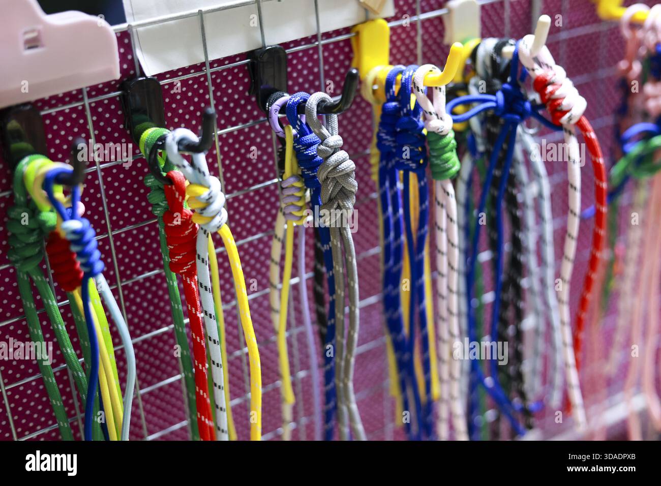 Farbenfrohes handgefertigtes Armband und Freundschaftskabel zum Verkauf auf einem Präsentationsständer. Nahaufnahme des lebendigen Knotenbades mit Seil und Schnur als Souvenir Stockfoto