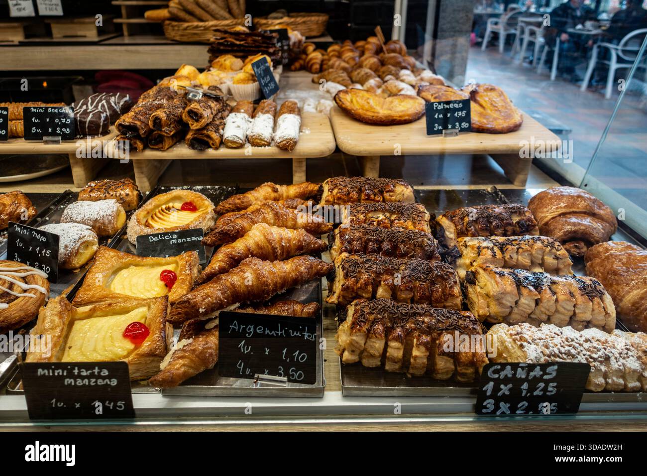 Bäckereifenster, spanisches Gebäck, Nahaufnahme. Malaga, Spanien, Konditorei, Innenbeleuchtung. Croissants, Cañas, palmeras, fertig zum Verkauf. Stockfoto