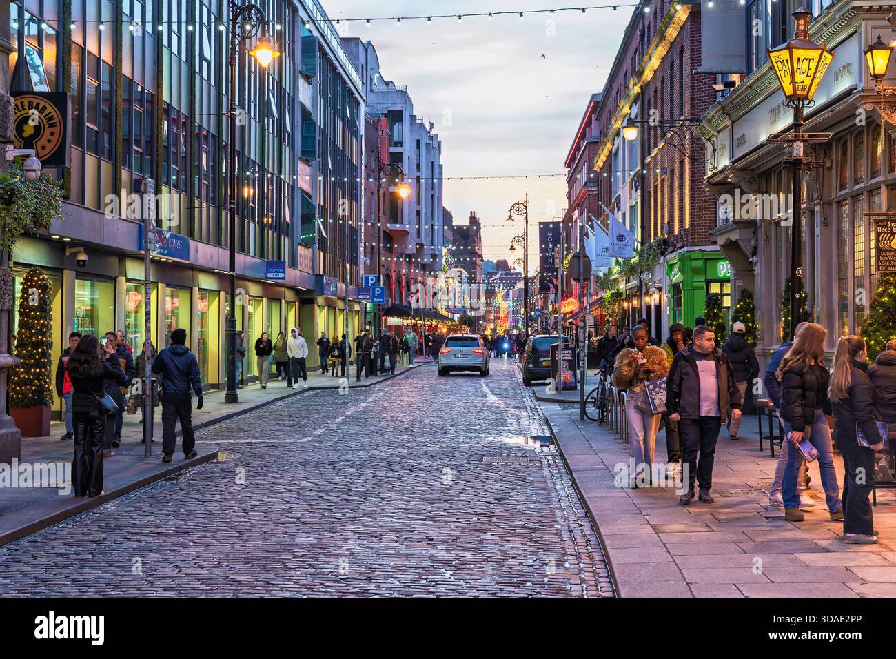 Historische Fleet Street in der Abenddämmerung, stimmungsvolle Kopfsteinpflaster, warme Lichter aus Pubs und Geschäften, subtile Fußgängerströme Stockfoto