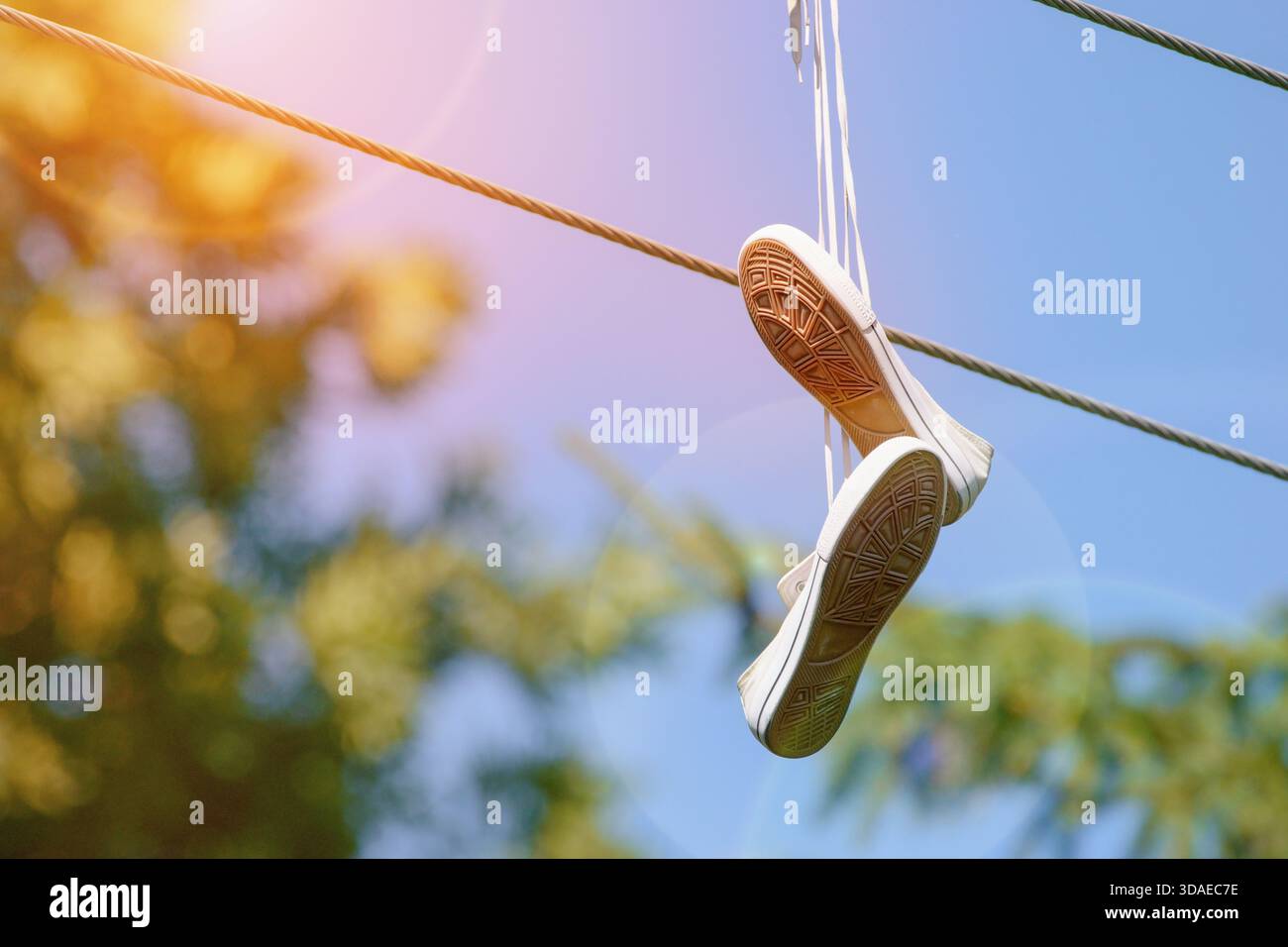 Sneakers hängen an den Stromleitungen. Schuhwerfen. Spaß oder Markierungsgebiet. Stockfoto