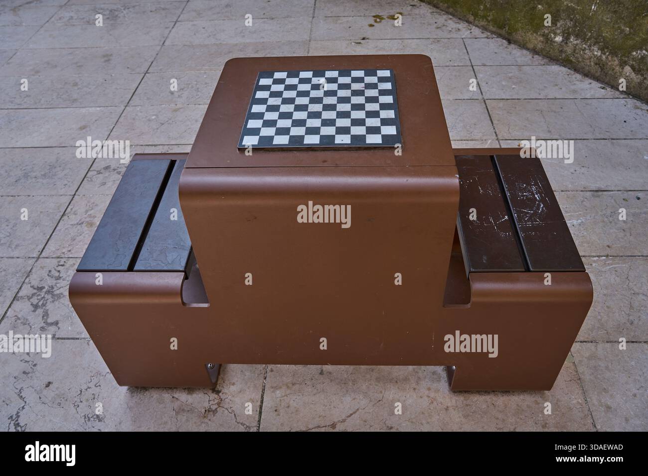 Moderner Schachtisch im Freien mit integrierten Sitzgelegenheiten auf einer Terrasse aus Stein Stockfoto