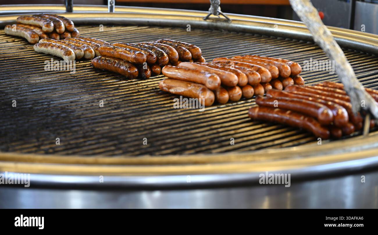 Würstchenreihen, die auf dem Grill gekocht werden Stockfoto
