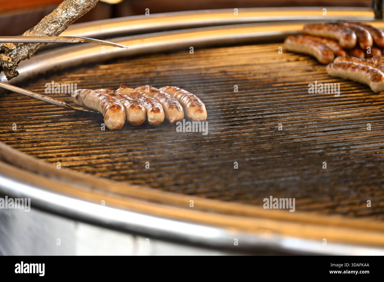 Würstchenreihen, die auf dem Grill gekocht werden Stockfoto