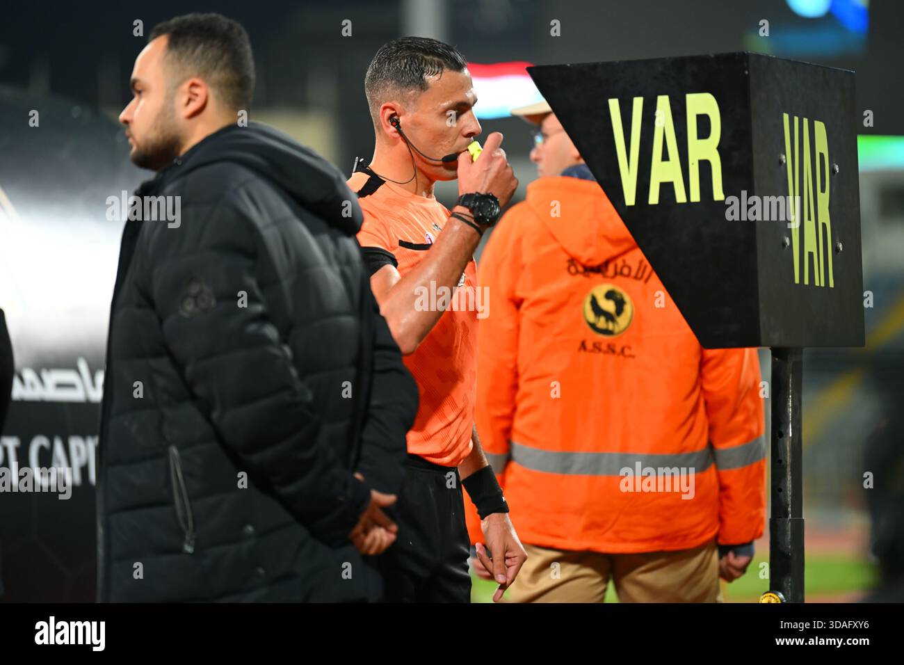 Ein Schiedsrichter überprüft einen Vorfall auf dem VAR-Monitor während eines Fußballspiels. Stockfoto