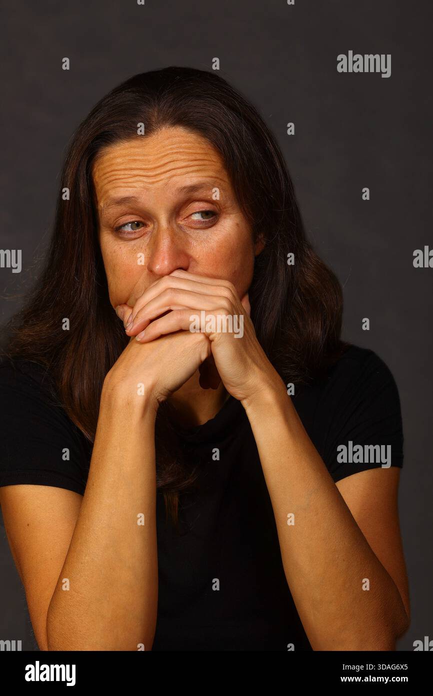 Ängstliche Frau, die den Mund bedeckt, in Angst, Schock und psychologischem Belastungskonzept Stockfoto
