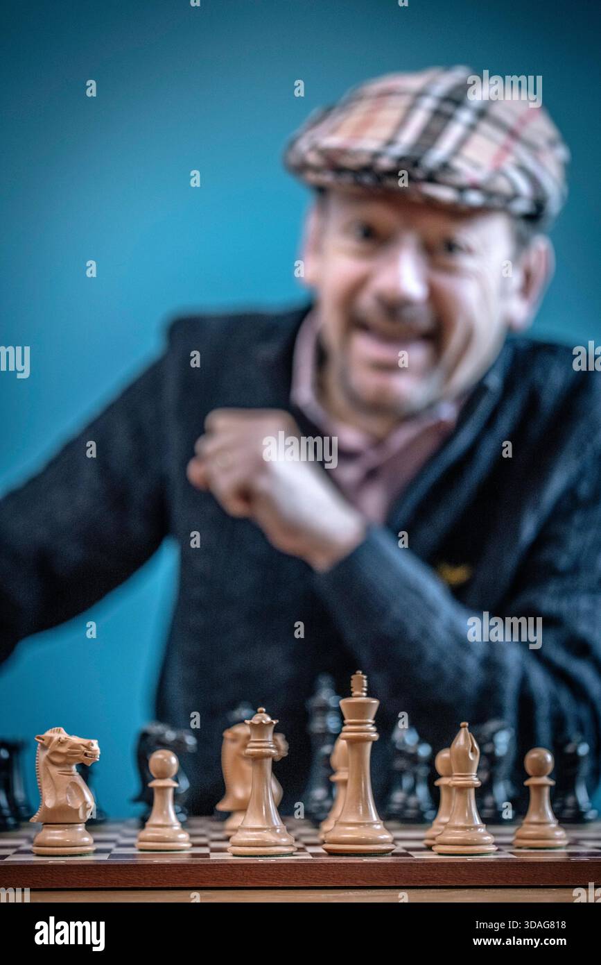 Mann, der Spaß beim Schachspiel auf dem Schachbrett hat Stockfoto