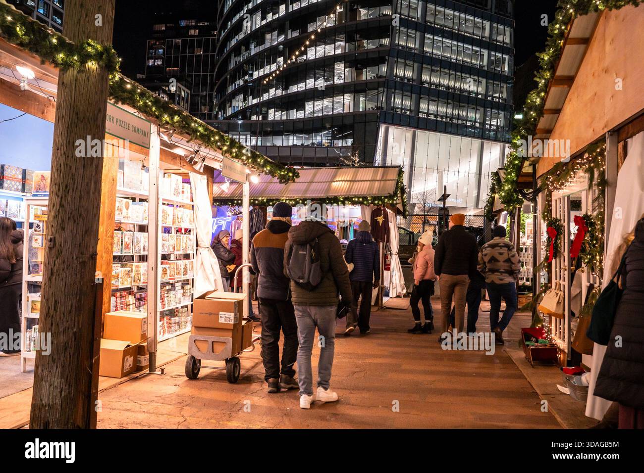 Boston, Massachusetts - 5. Dezember 2025: Blick auf den Weihnachtsmarkt, Snowport, bei Nacht aus dem Seaport District in Boston. Stockfoto