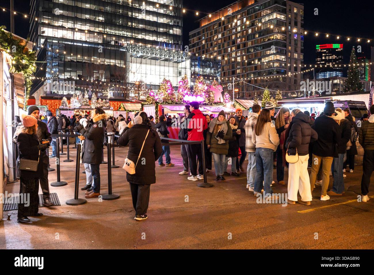 Boston, Massachusetts - 5. Dezember 2025: Blick auf den Weihnachtsmarkt, Snowport, bei Nacht aus dem Seaport District in Boston. Stockfoto