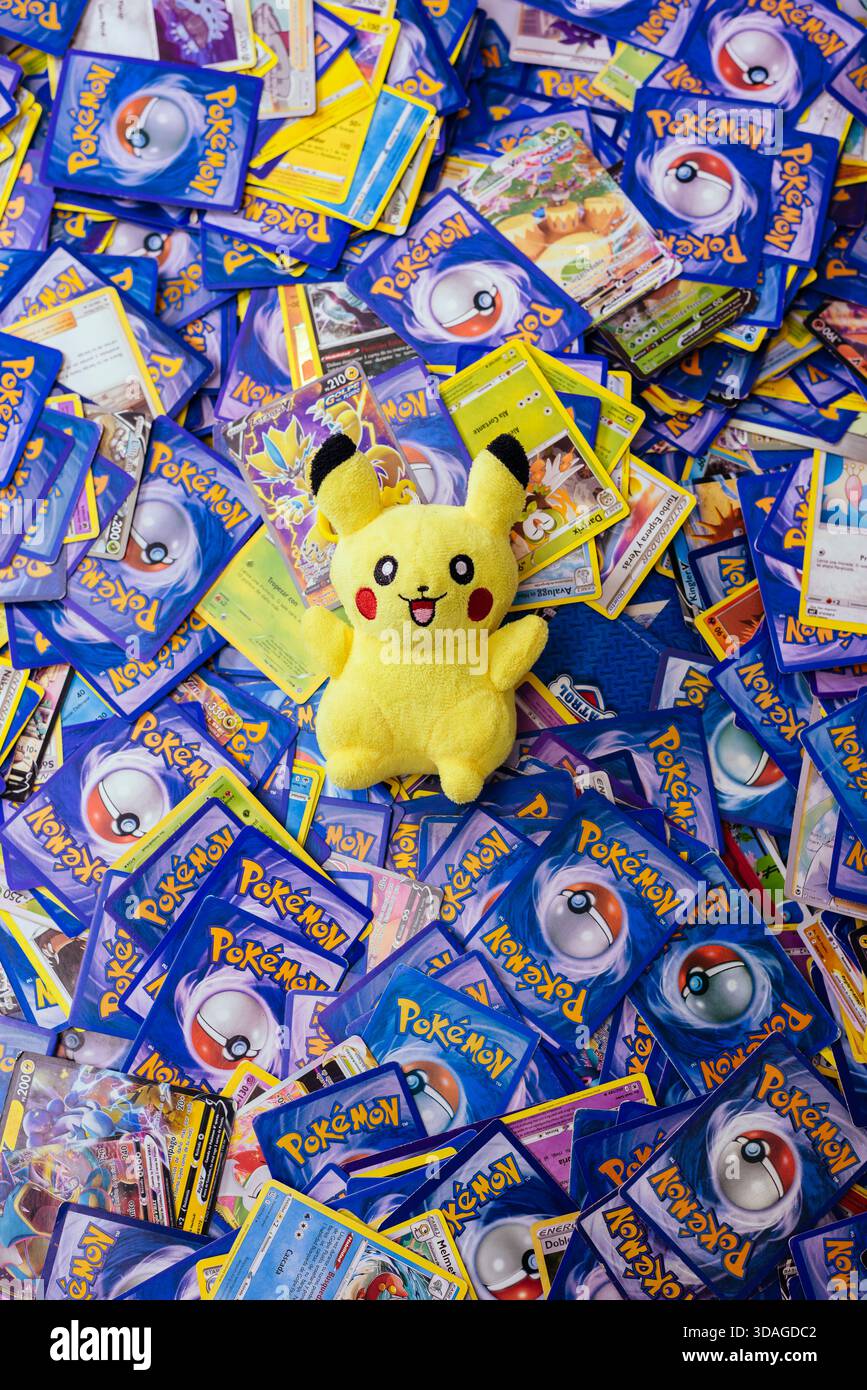 Valencia, Spanien - 10. Dezember 2025: Pokémon-Tauschkarten-Spielszene mit Pikachu Plüschtier in farbenfroher Umgebung Stockfoto